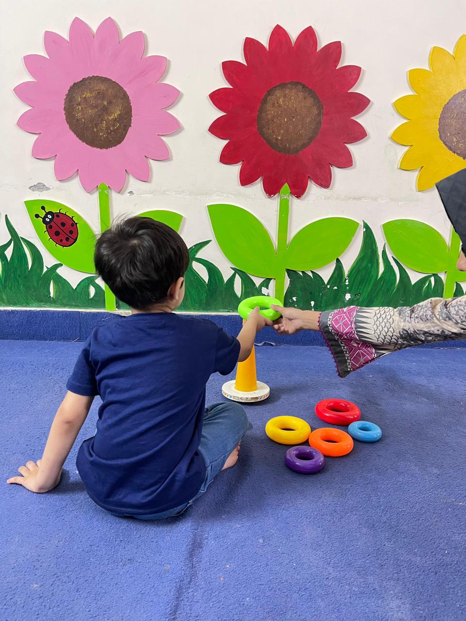 ABA therapy ring stacking activity developing focus and fine motor skills at Global Kids Campus Therapy Centre Lahore