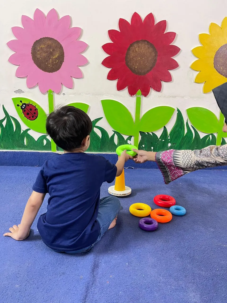 ABA therapy ring stacking activity developing focus and fine motor skills at Global Kids Campus Therapy Centre Lahore