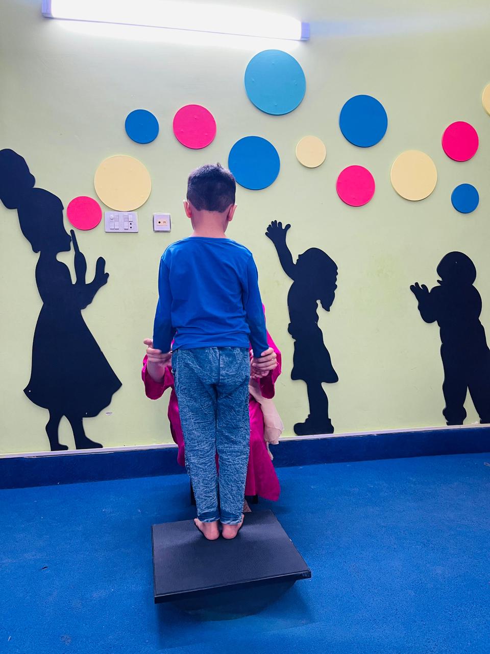 Child standing tall on balance board at Global Kids Campus Therapy Centre Lahore