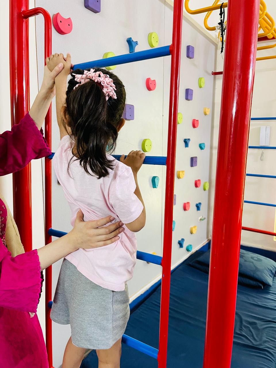 Child building strength and confidence on monkey bars at GKC Therapy Centre Lahore